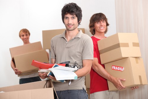 Professional movers loading household items into a van